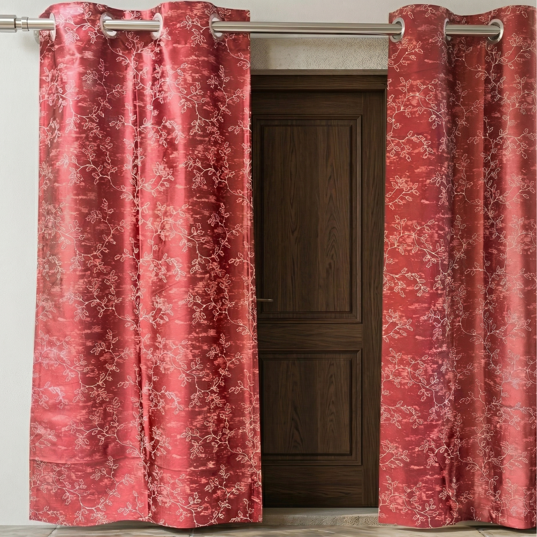 Red floral patterned curtains with grommets on a wooden door.