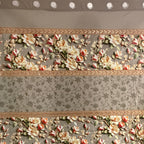 Floral patterned curtain with decorative border on a plain background