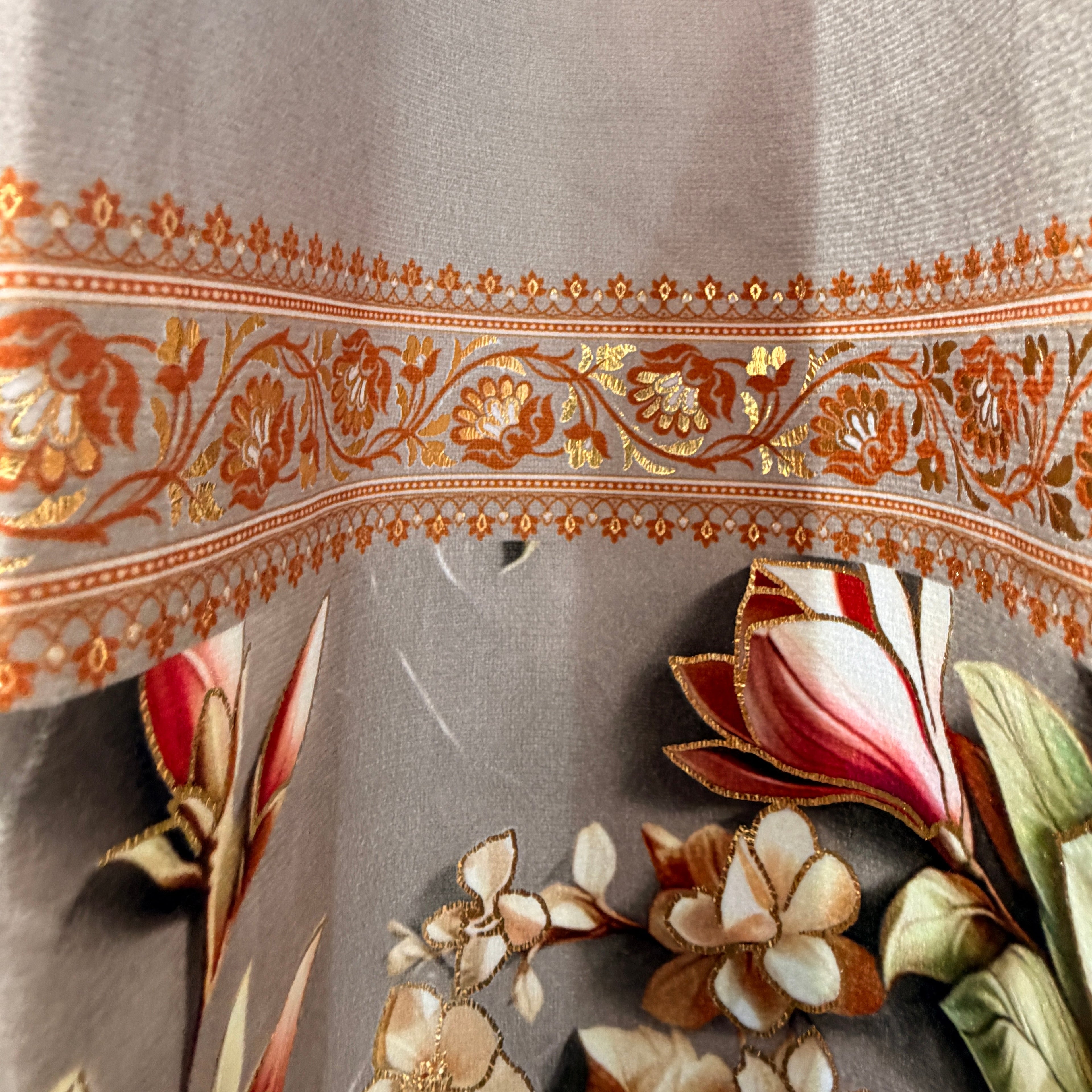 Decorative fabric with floral embroidery and intricate patterns on a gray background